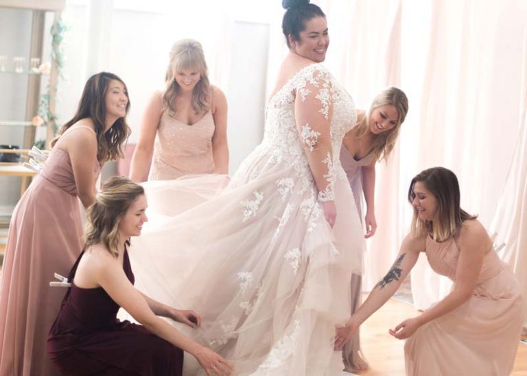 Image of a bride and bridesmaids having fun during a fitting
