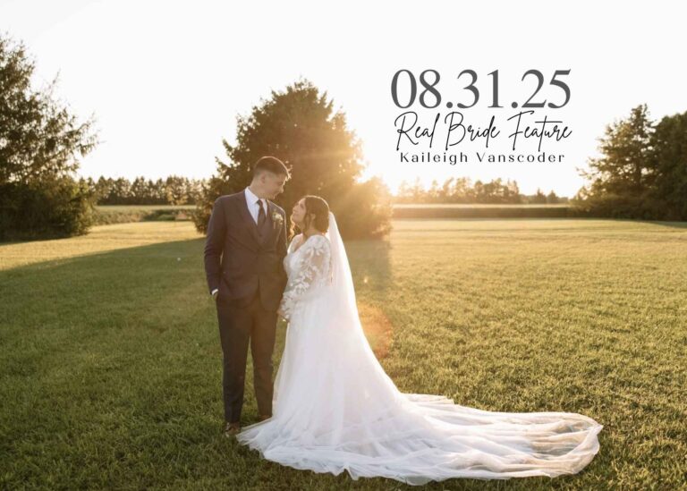 Bride Kaileigh Vanscoder standing with her groom in a sunlit field, wearing a long-sleeve lace wedding gown with a flowing train as golden-hour light shines behind them.