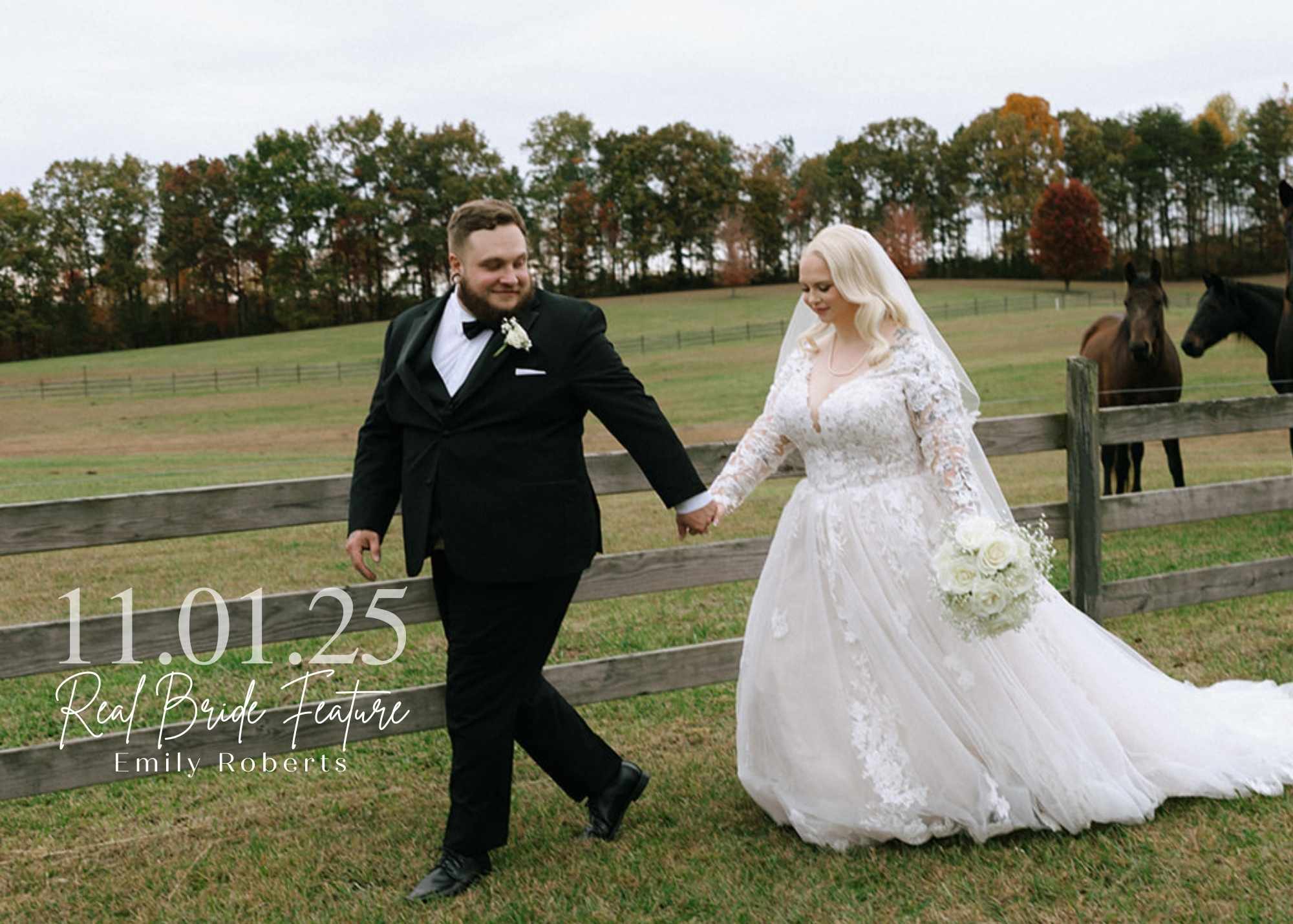 Bride Emily Roberts walking hand-in-hand with her groom across a farm property, wearing a long-sleeve lace ball gown and holding a white rose bouquet, with horses and fall foliage in the background.