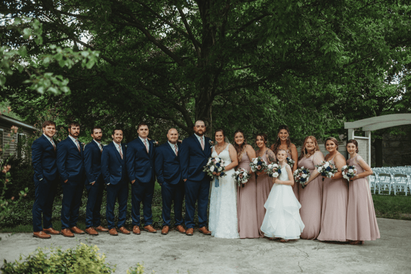 Bride and groom with their bridal party wearing coordinated tuxedo and bridesmaid dress colors