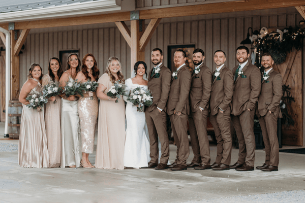 Bride and groom standing with their bridal party in coordinated wedding colors.