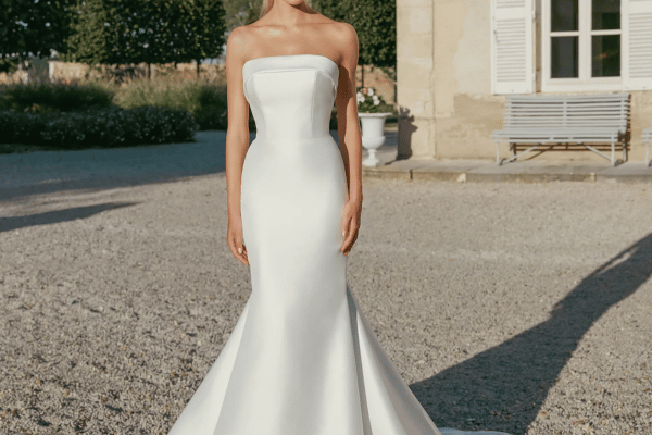 A bride in her white strapless wedding gown, hands to the sides