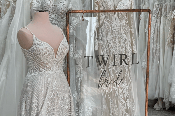 Elegant lace wedding gowns displayed on mannequins; delicate patterns create a romantic scene.