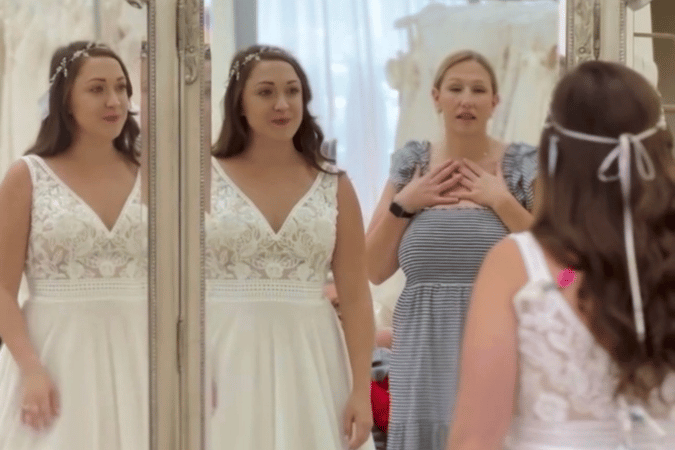 Bride trying on a wedding dress while looking in the mirror during a bridal appointment at Twirl Bride.