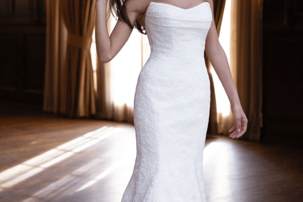 Bride wearing a mermaid wedding dress with a fitted silhouette that hugs the body through the hips.