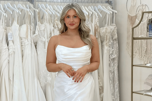 Bride wearing a wedding dress in a bridal boutique while exploring options and backup plans for a delayed wedding gown.
